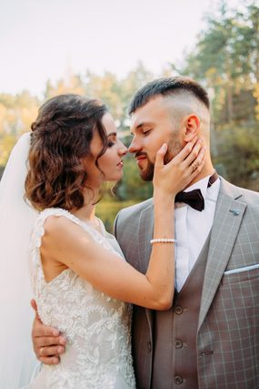 Bride touching the groom's face as they lean in close
