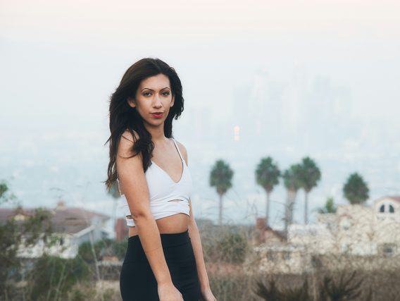 Woman in a white top on a hill above a hazy city