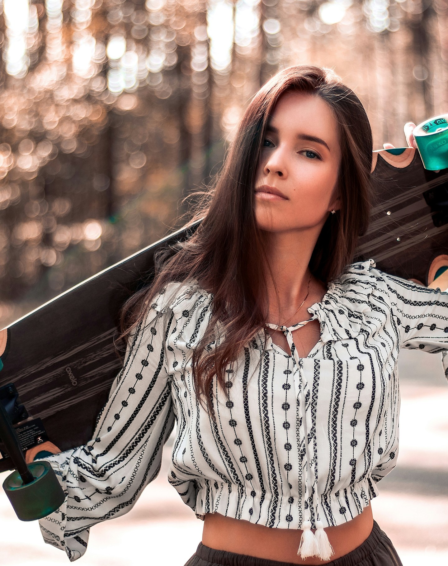 Before: woman holding a longboard on a forest road