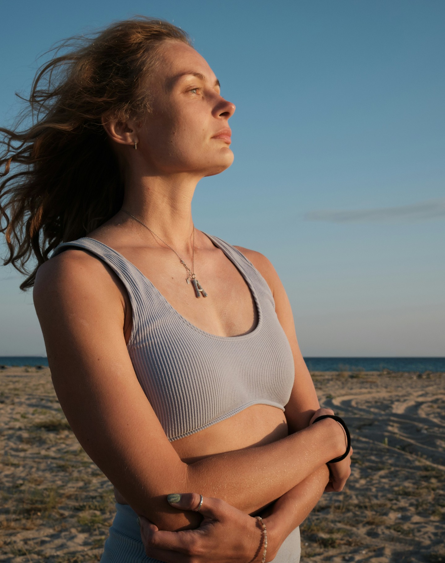 Before: woman on a beach at golden hour with wind in her hair