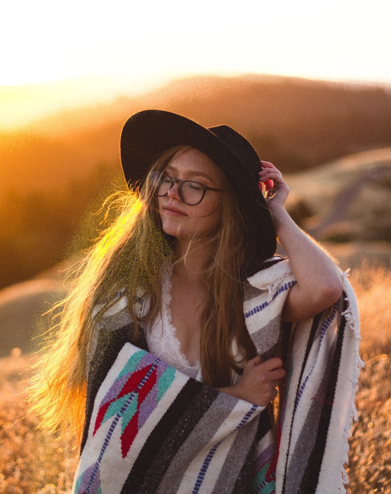 Light Rays Photoshop action after: woman in a hat at sunset with strong light rays