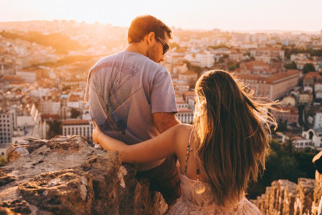 Couple looking out over a city at sunset