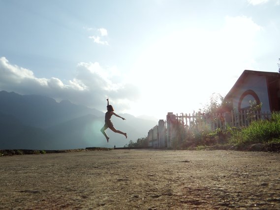 Person leaping on a road at dawn