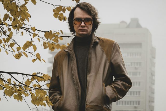 Man in tinted glasses and a leather jacket on a foggy day