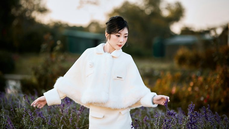 Woman in a white coat walking through a lavender field