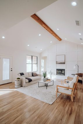 Bright living room with a vaulted ceiling, sofa and fireplace