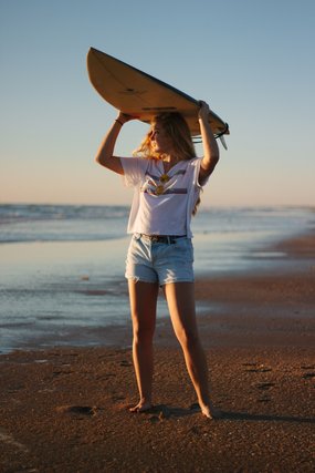 Woman carrying a surfboard on her head