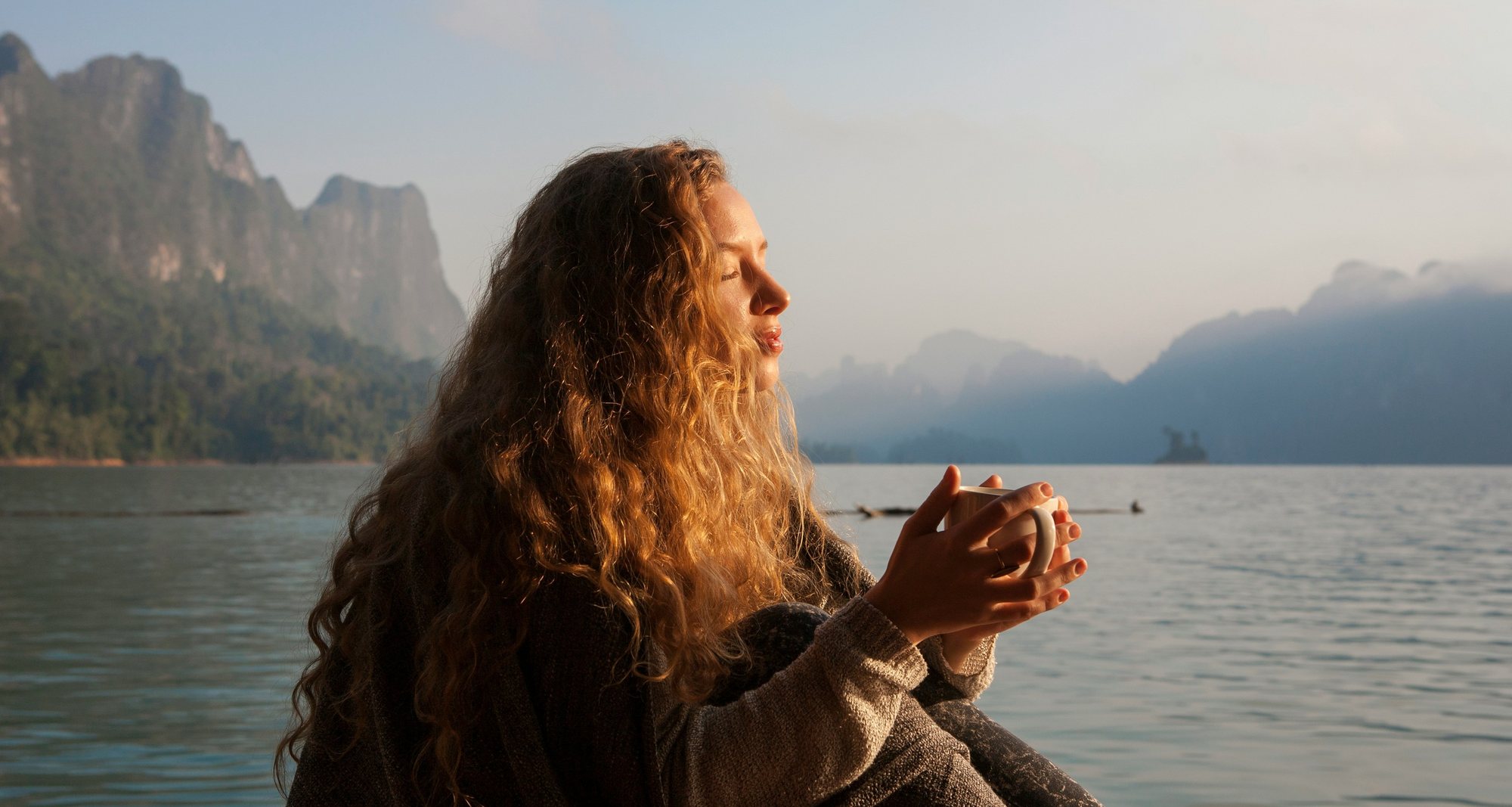 Before: a woman holding a mug by a mountain lake