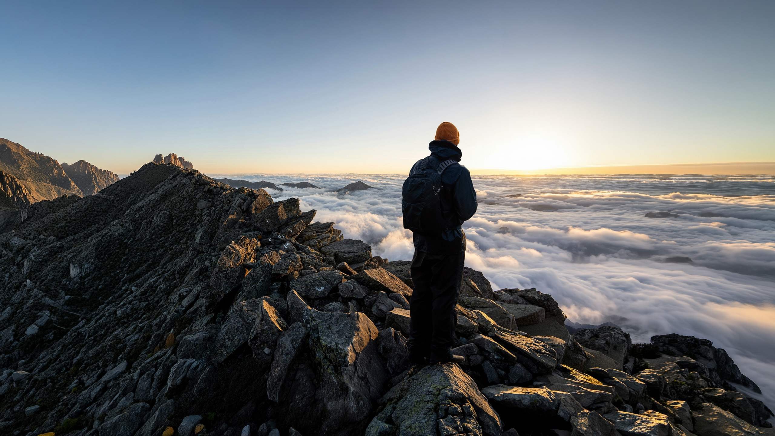 Hiker standing on a mountain top above the clouds at sunset, the composite used to test Relight in Photoshop