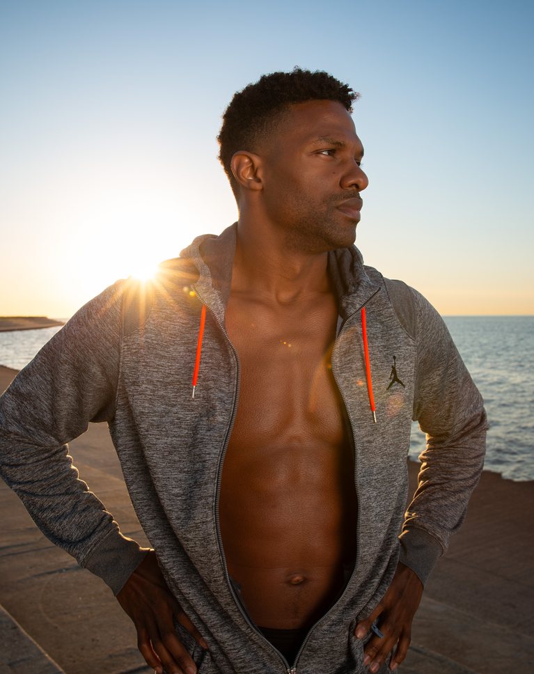 The same sunrise portrait with natural dark skin tones corrected in Camera Raw, a richer sky and a brighter face