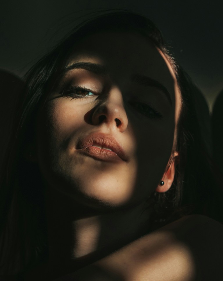 A woman in dramatic window light with her eyes half closed, before the gradient map