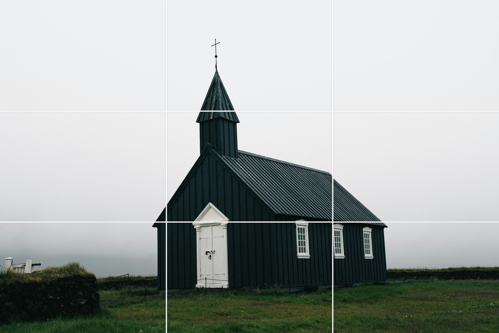 A black wooden church in fog in Iceland placed in the centre of the frame, grid overlaid