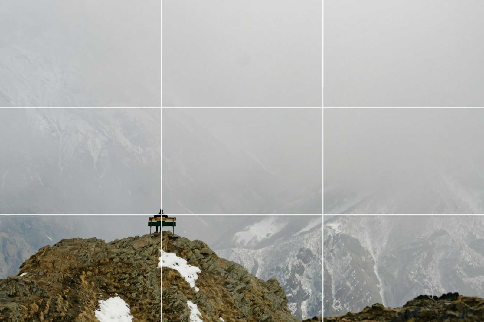 The same summit scene cropped so the bench sits where two rule-of-thirds lines cross, with the grid drawn over the photo