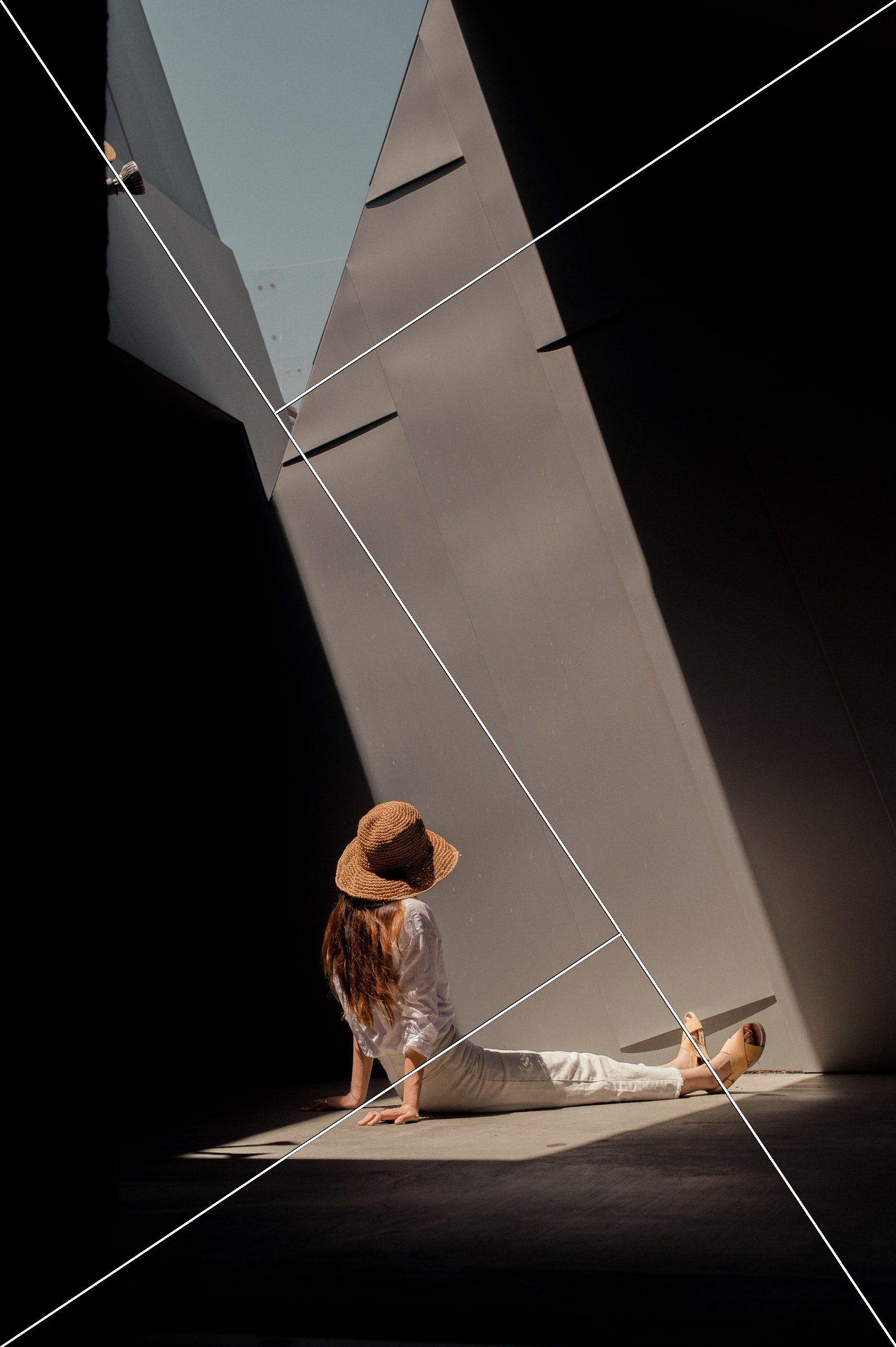 Golden triangle overlay on a photo of a person sitting in a beam of light that cuts diagonally across a dark room