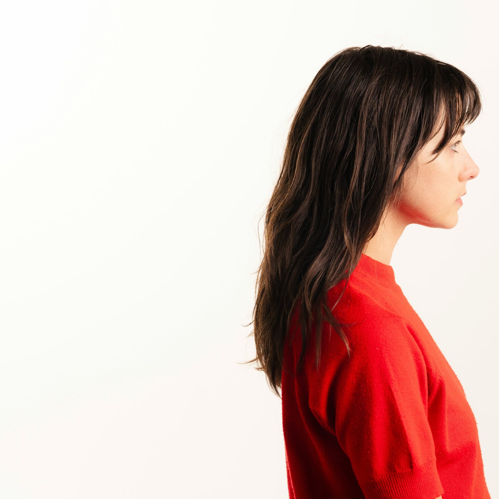 The same photo cropped so she is at the right edge, facing it, with the white space behind her