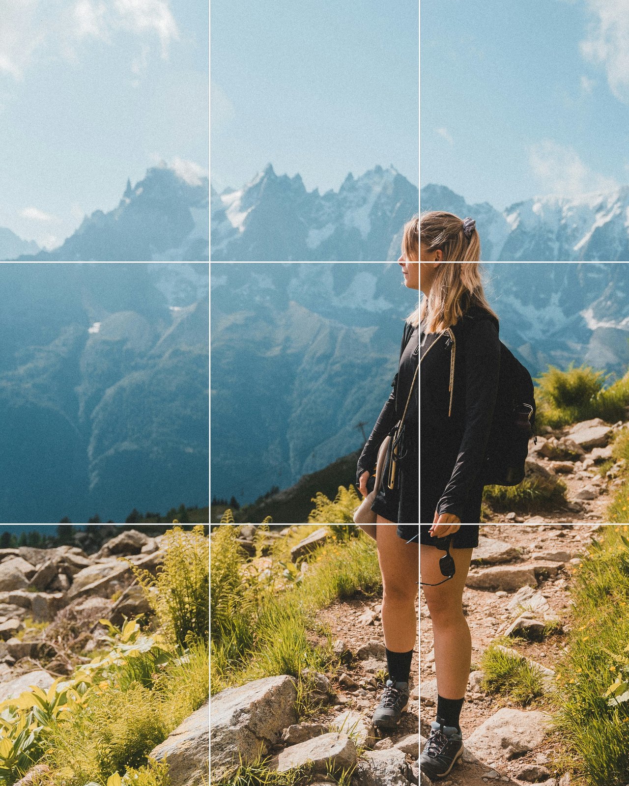 A woman hiking at Mont Blanc placed on the right third of the frame, looking left toward the mountains, grid overlaid