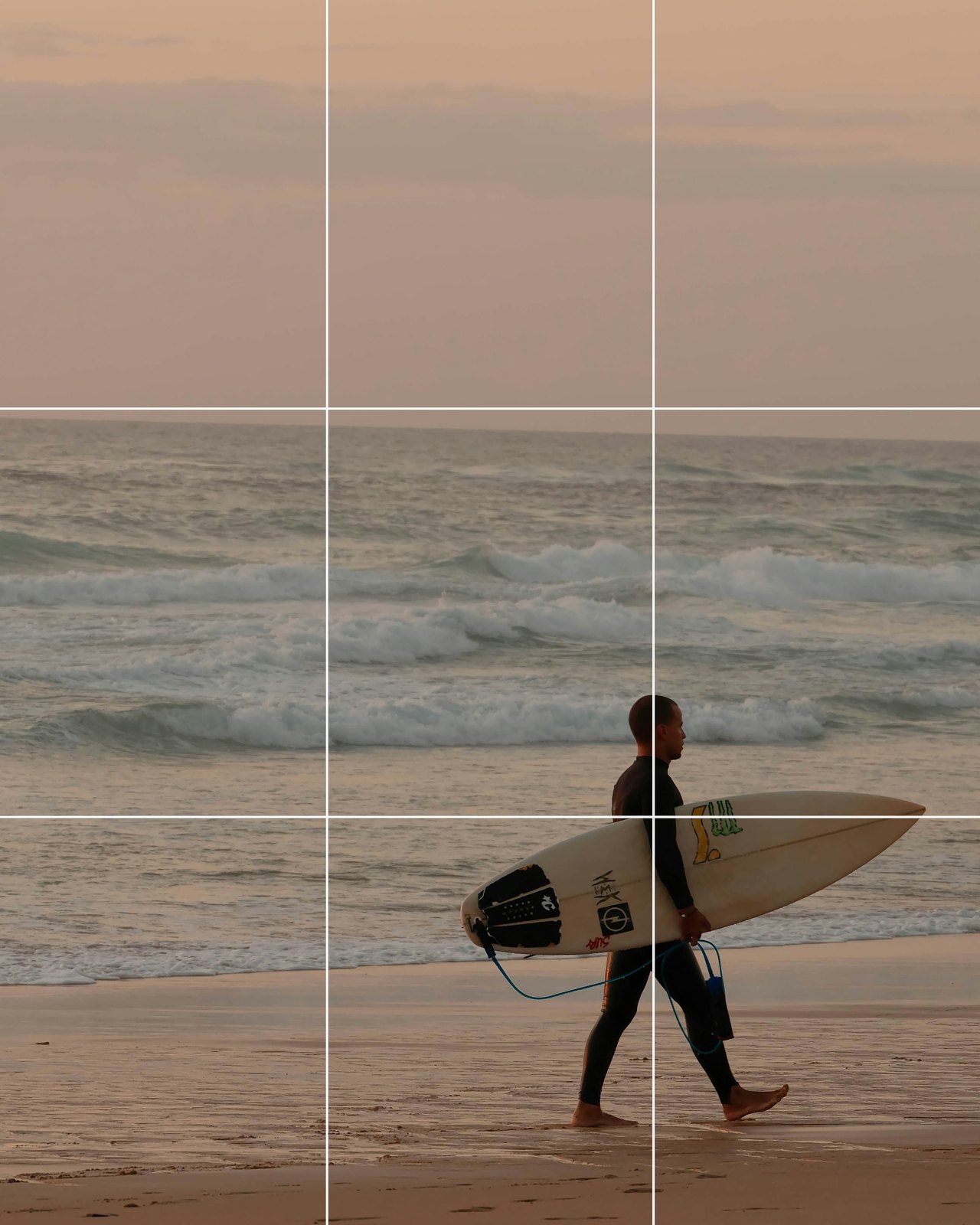 A surfer carrying a board along a beach at sunset, placed on the lower right crossing point of the grid with the horizon on the top line